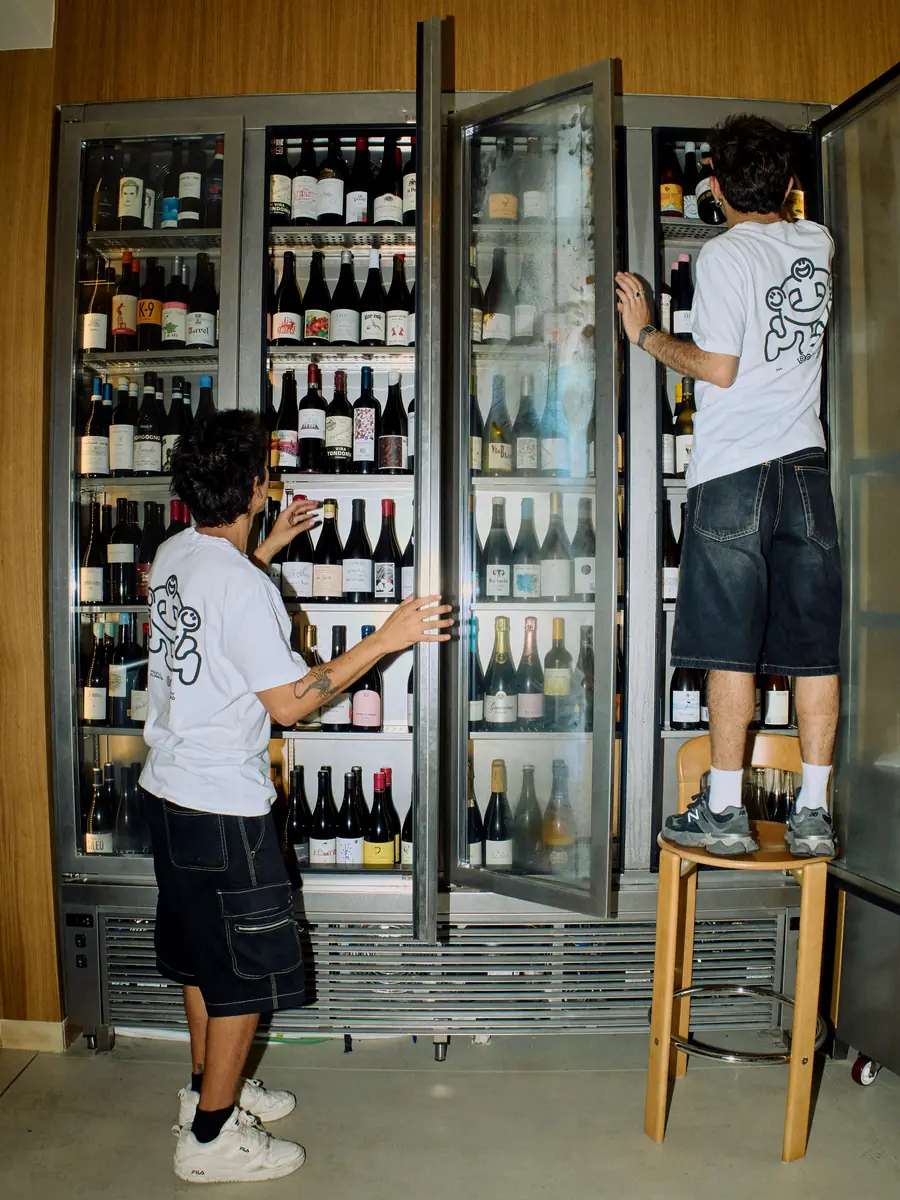 Dos camareros eligen vinos en la nevera de Bar Amicks